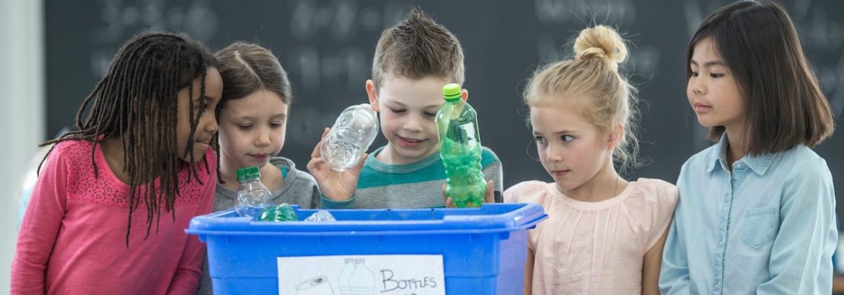 School Children Learning To Recycle Plastic Bottles