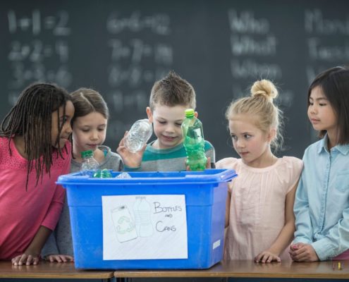 School Children Learning To Recycle Plastic Bottles